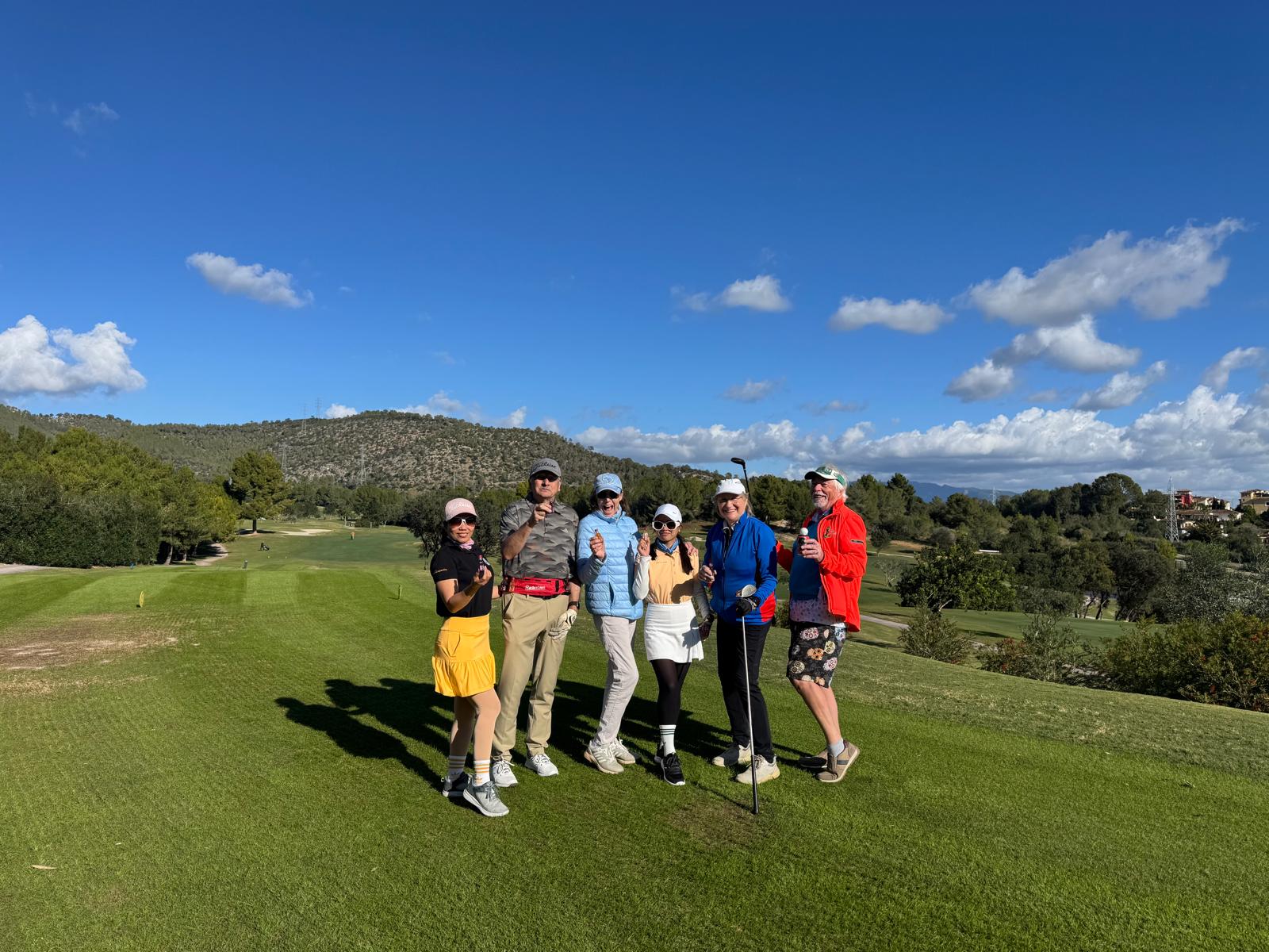 Gruppe auf dem Fairway mit Bergpanorama